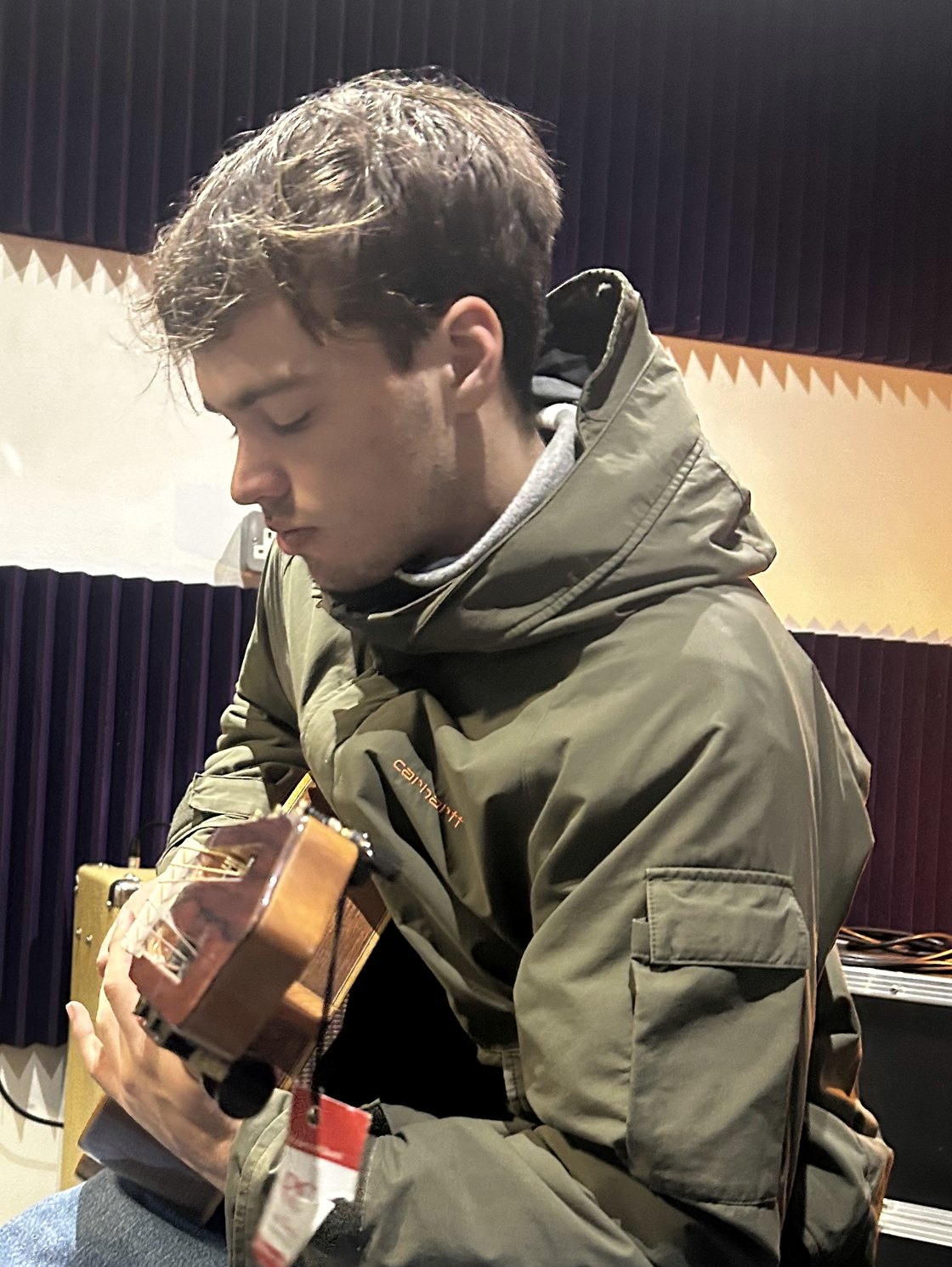 Rufus Carr, playing guitar in a rehearsal room